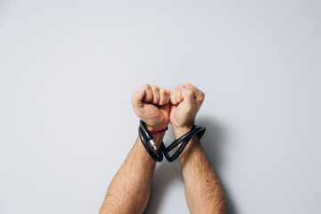 Male hands tied by a metal chain. Day of the struggle for the abolition of slavery.