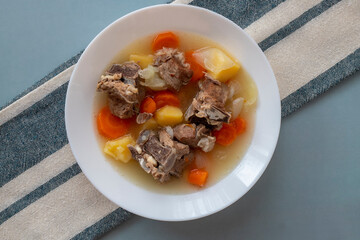 Boiled lamb meat with potatoes, carrots , onions, top view, copy space. Homemade winter comfort food.