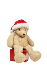 Ours en peluche avec bonnet de Noël assis sur une boîte cadeau rouge