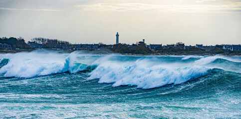 stürmisches, tosendes, aufgewühltes Meer mit hohen Wellen und Gischt in den Klippen an der Pointe de la Torche, Frankreich, Bretagne, Finistère  mit Blick auf den Leuchtturm Eckmühl © JM Soedher
