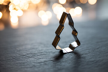 Christmas Tree Cookie cutter in front of christmas lights. Selective focus, copy space