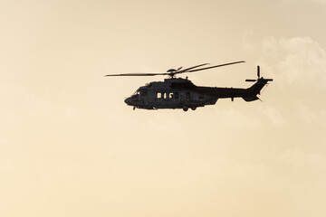 Fototapeta na wymiar Hubschrauber, Helikopter im Tiefflug über dem Meer bei wolkenhimmel