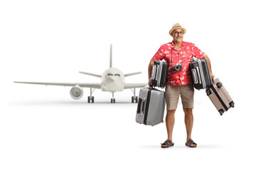 Mature male tourist with many suitcases in front of a plane