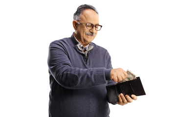 Mature man smiling and putting money in a wallet