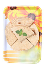 closeup the bunch brown color tortilla with green mint in the yellow white plastic tray on the white background.