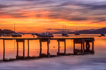 Fototapeta premium Scenic view of bay with dock and boats on the french riviera in summer after colorful sunset