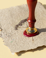 Wax printing with fire paint on homemade kraft paper with pressed dried flowers. Sealing wax seal...