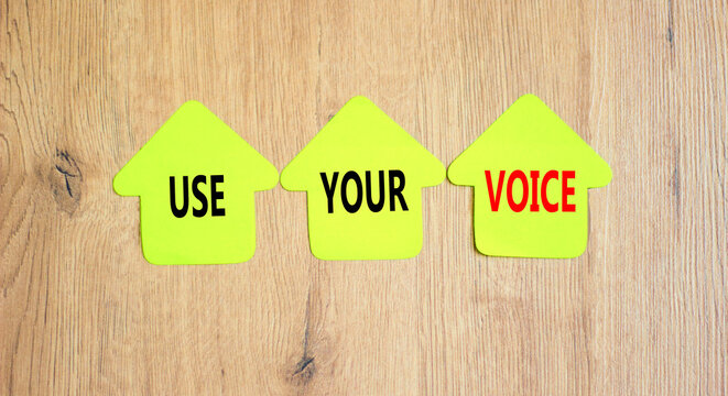 Use your voice symbol. Concept words Use your voice on green paper house on a beautiful wooden table wooden background. Business and use your voice concept. Copy space.