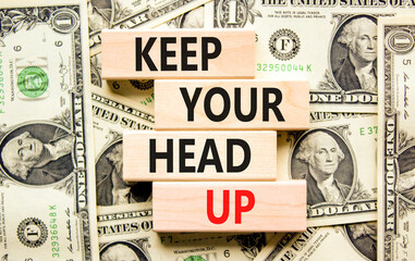 Keep your head up symbol. Concept words Keep your head up on wooden cubes. Beautiful background from dollar bills. Business motivational keep your head up concept. Copy space.