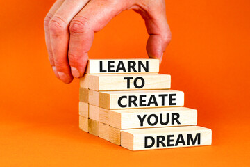 Create your dream symbol. Concept words Learn to create your dream on wooden blocks. Businessman hand. Beautiful orange table orange background. Business learn to create your dream concept. Copy space