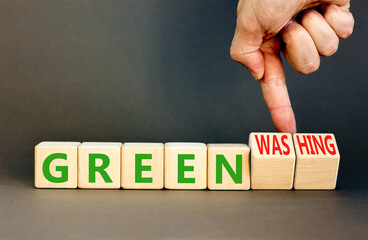 Green or greenwashing symbol. Concept words Green and Greenwashing on wooden cubes. Businessman...