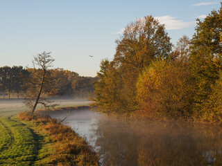Fototapeta na wymiar Herbstmorgen an einem Fluß im Münsterland