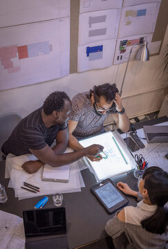 Architects discussing schematics in conference room meeting
