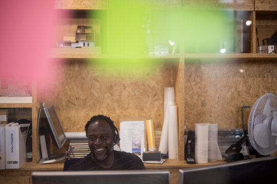Smiling businessman in headset working at office computer
