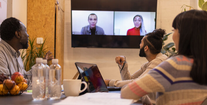 Business people video conferencing with colleagues in office