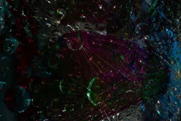 Space abstraction. Spheres of various diameters are illuminated by purple-blue-green flashes of light on a black background. 3D render.