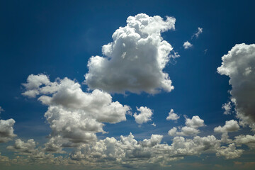 White puffy cumulus clouds on summer blue sky