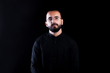 Obraz premium Beard man in black shirt on black background