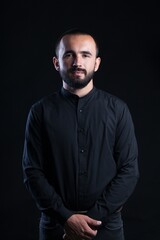 Beard man in black shirt on black background