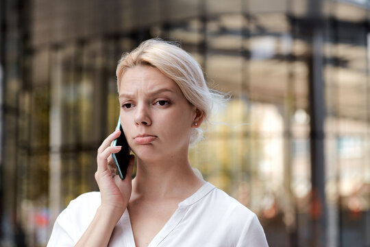 Professional business woman disapointed irritated girl talking to the mobile phone outside. Professional female talking the phone