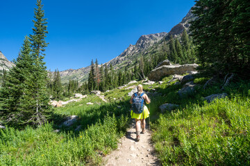 Woman backpacker hikes along the Cascade Canyon trail in Grand Teton National Park