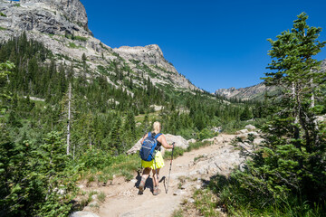 Fototapeta na wymiar Woman hiker makes her way though the Cascade Canyon trail in Grand Teton National Park