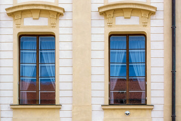 Two rectangular windows with a visor on the background of a yellow wall. From the Windows of the world series.