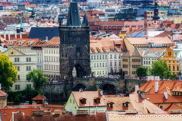 Tiled roofs of the city of Prague and a fragment of the Charles Bridge over the Vltava River.