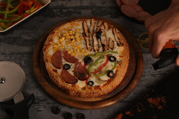Mix pizza, sausage, vegetables and chicken breast, on a gray background