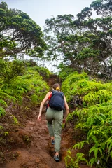 Fototapeten hiker girl climbs steep trail on oahu with honolulu skyline in background on wiliwilinui ridge trail  hiking on green mountains in hawaii, holiday in hawaii © Jakub