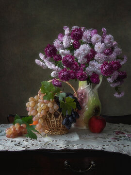 Still life with bouquet of chrysanthemums and grapes