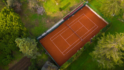 View of the clay tennis court. The sports field is empty.