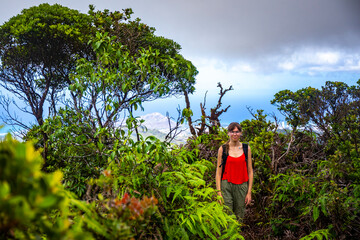 hiker girl walks path among unique, dense, luscious green vegetation of hawaii, wiliwilinui ridge trail; hiking in hawaii islands mountains near honolulu, active holidays in hawaii
