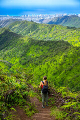 hiker girl enjoys the panorama of oahu island and honolulu in hawaii islands while climbing wiliwilinui ridge trail; hiking on green mountains in hawaii, holidays in hawaii