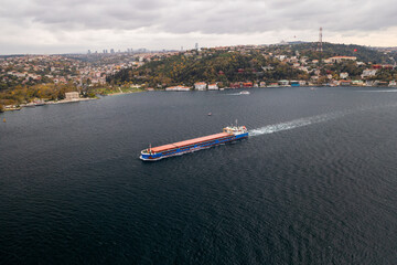 Tanker, cargo ship passes through the Bosporus. Awesome view of the Bosphorus Bridge (the 15 July Martyrs Bridge) connecting Europe to Asia.