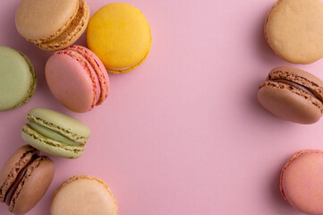Macaroons colorful cookies. Macarons french sweet dessert, top view, pink background. Copy space