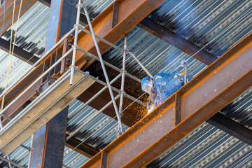 rusted steel structure while a man is welding joints, mexico guadalajara