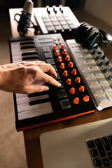 Musician's hand on midi keyboard, synthesizer. Recording studio, music studio, radio, music school, home studio. Close-up. Advertising, banner, invitation.