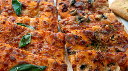 Pizza by the slice displayed in a tray, close up