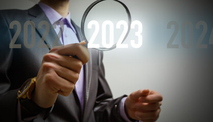 Obraz premium Finger pressing blue start 2023 button on virtual interface on gray background with copy space for text. Concept of new year. Businessman pressing 2023 start up business. Beginning of New Year 2023.