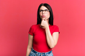 young adult pretty woman thinking, feeling doubtful and confused, with different options, wondering...