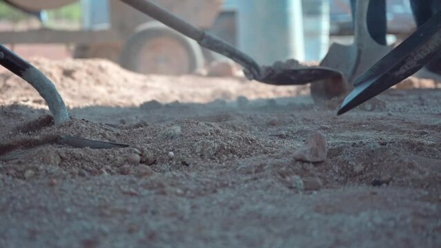 Closeup shot of people working with sapper shovel in the sand