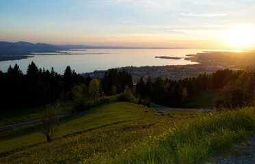 	
sunlit alpine view from Eichenberg in the Austrian Alps and the German side of lake Constance with island of Lindau in the evening sun in spring
