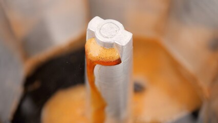 Making Black coffee with foam. Hot coffee pour from geyser coffee maker, macro