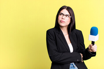 shrugging, feeling confused and uncertain. journalist or presenter with a micro