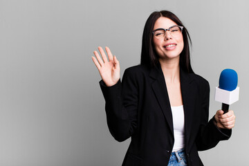 smiling happily, waving hand, welcoming and greeting you. journalist or presenter with a micro