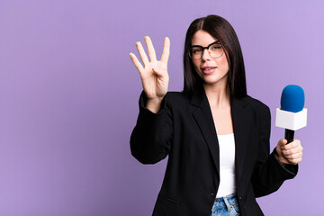 smiling and looking friendly, showing number four. journalist or presenter with a micro