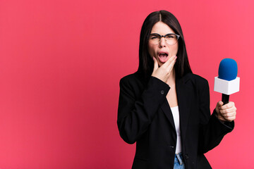 with mouth and eyes wide open and hand on chin. journalist or presenter with a micro