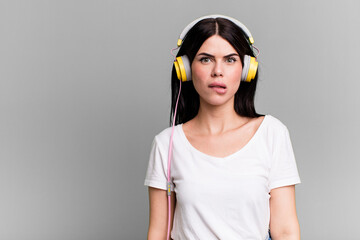 looking puzzled and confused. listening music qith a headphones