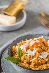 Homemade pumpkin risotto with parmesan cheese on a gray concrete background